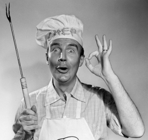 1950s 1960s man wearing chef hat holding barbecue grilling fork making okay sign looking at camera